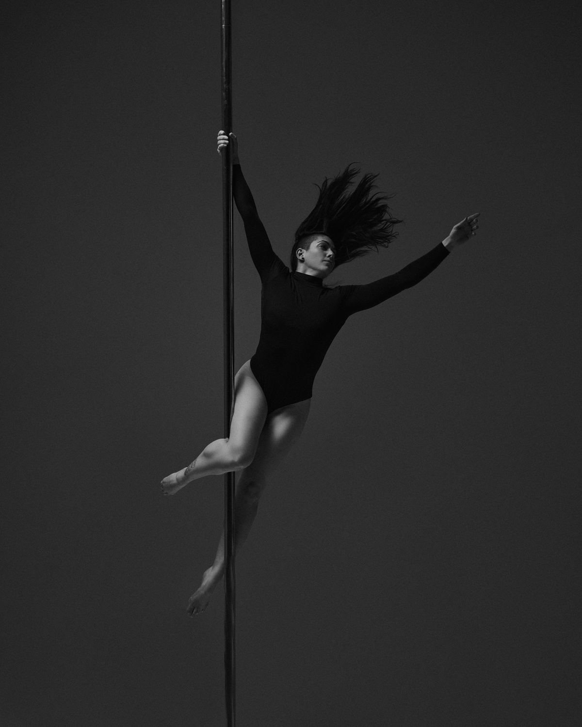 Carla Regueira performing a dynamic pole move in Barcelona